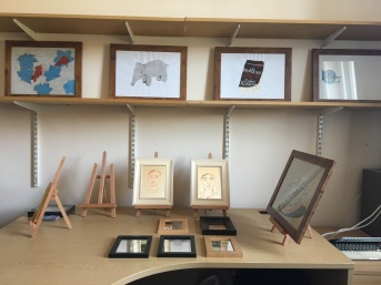 A few samples of original work on objects and of composite portraits. The public activity replicating the latter had place on the left of the desk.